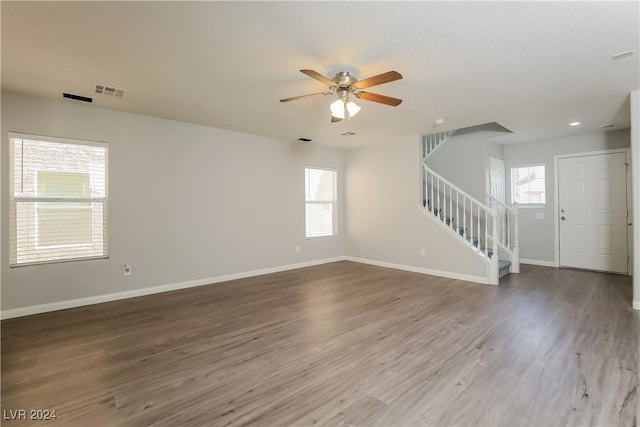 spare room with ceiling fan, a wealth of natural light, and wood-type flooring