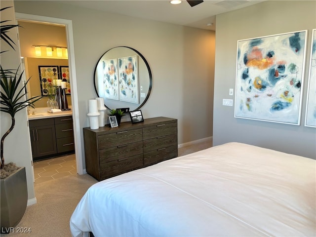 carpeted bedroom with ceiling fan, ensuite bath, and sink