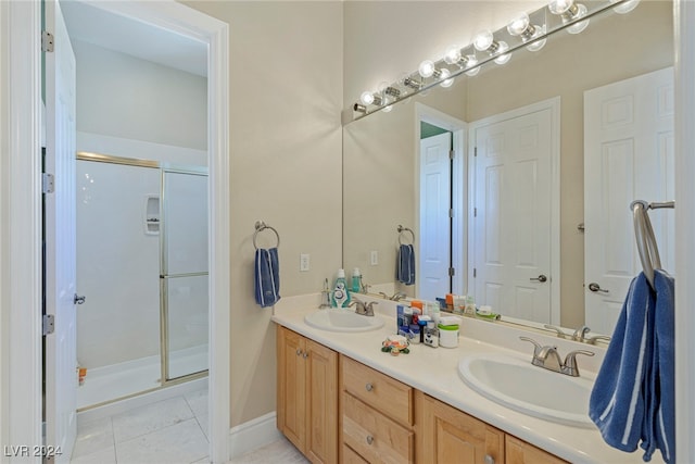 bathroom featuring tile patterned flooring, a shower with door, and vanity