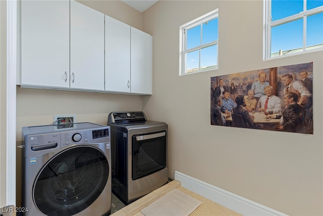 laundry room with separate washer and dryer and cabinets