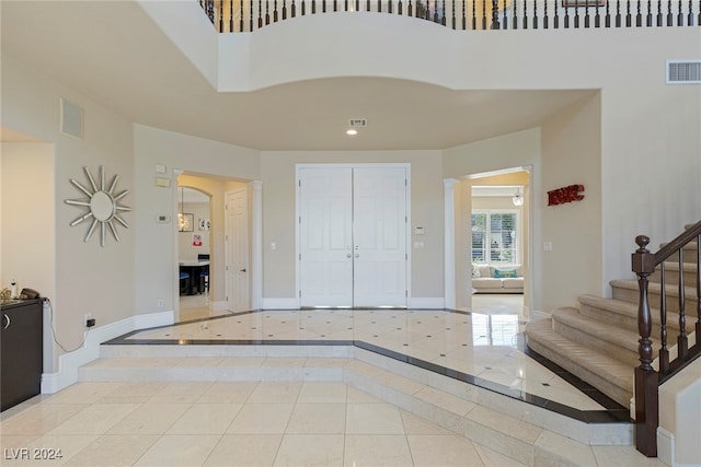 tiled foyer entrance with a towering ceiling