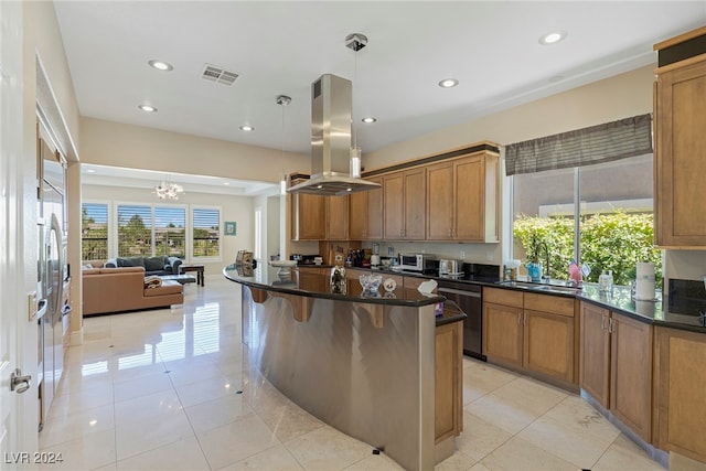 kitchen featuring island exhaust hood, decorative light fixtures, sink, a kitchen bar, and stainless steel dishwasher