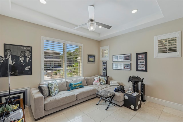 tiled living room featuring ceiling fan and a raised ceiling