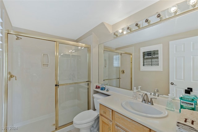 bathroom featuring vanity, toilet, and a shower with door