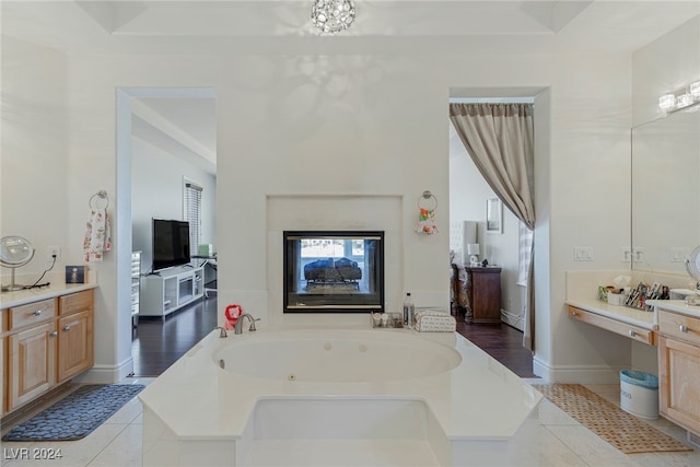 bathroom with tile patterned floors, a tub to relax in, and vanity