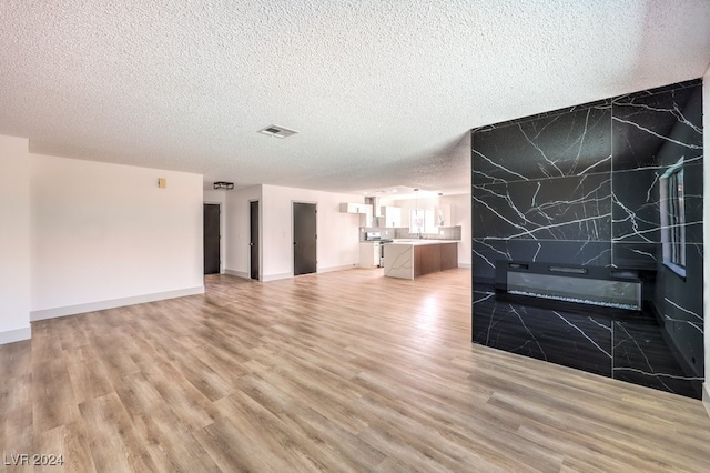 unfurnished living room with a textured ceiling and hardwood / wood-style floors