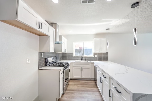 kitchen featuring white cabinets, sink, decorative light fixtures, and stainless steel appliances