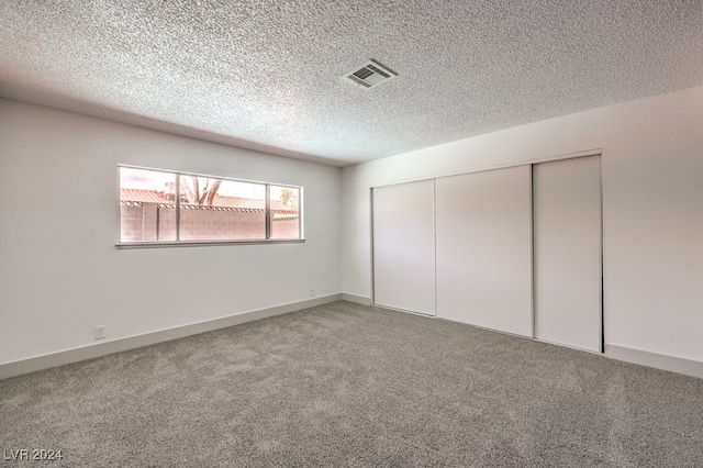 unfurnished bedroom with a textured ceiling, a closet, and carpet