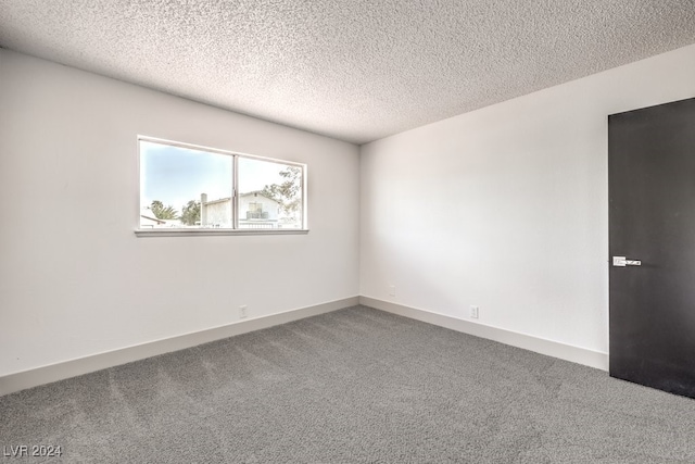 unfurnished room with a textured ceiling and carpet flooring