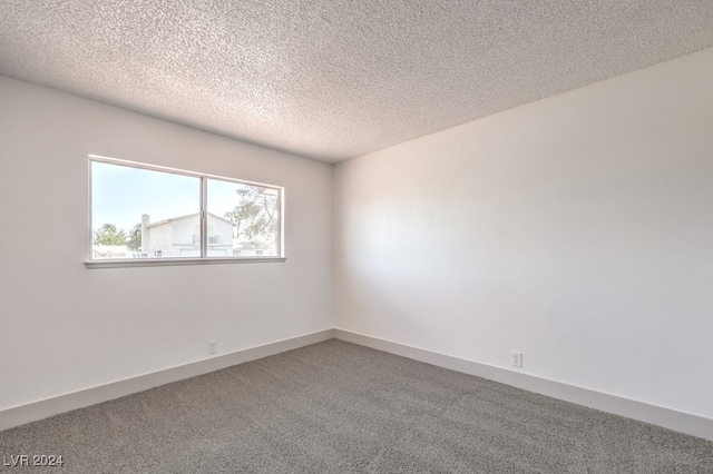 empty room with a textured ceiling and carpet