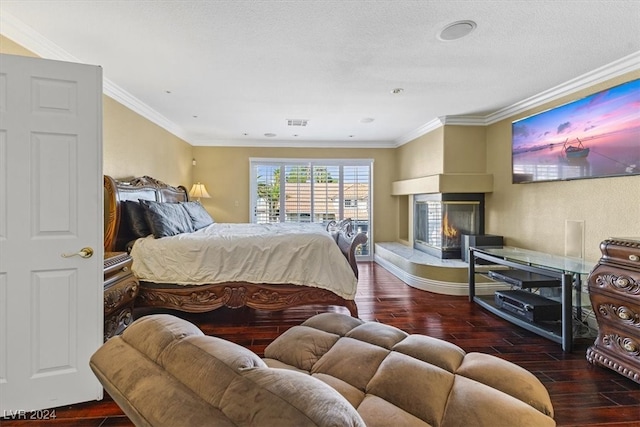 bedroom with a multi sided fireplace, dark hardwood / wood-style floors, crown molding, and a textured ceiling