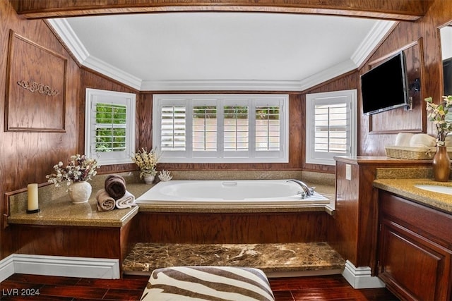 bathroom with wood-type flooring, a bathing tub, crown molding, and vanity