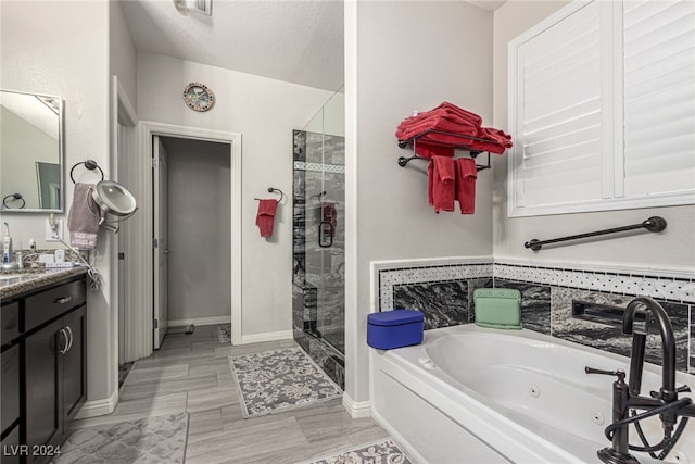 bathroom with vanity, a textured ceiling, and shower with separate bathtub