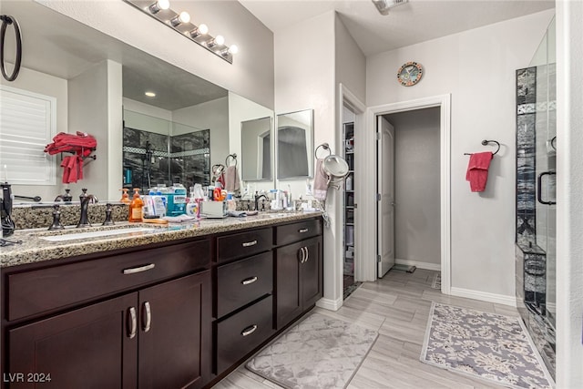 bathroom with vanity, a shower with shower door, and wood-type flooring