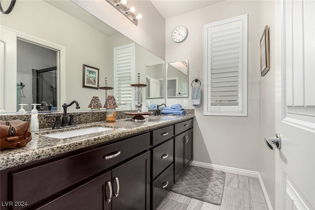 bathroom with vanity and a shower with door