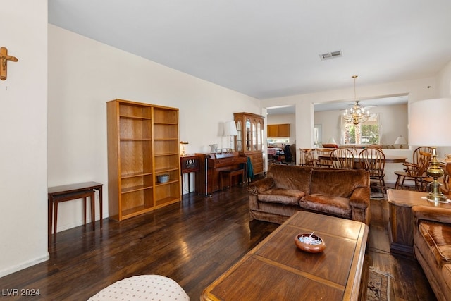 living room featuring an inviting chandelier and dark hardwood / wood-style flooring