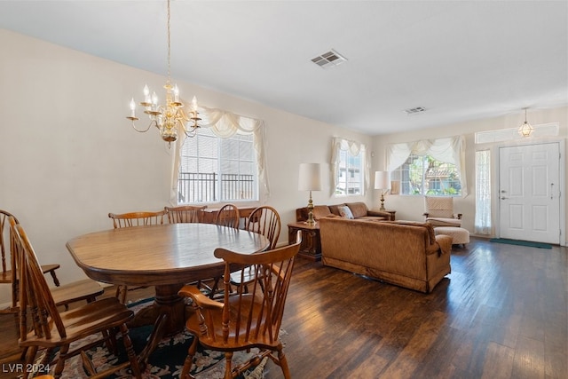 dining area featuring dark hardwood / wood-style floors and an inviting chandelier