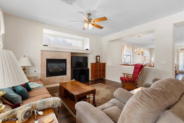 living room featuring a fireplace, dark hardwood / wood-style flooring, a wealth of natural light, and ceiling fan with notable chandelier