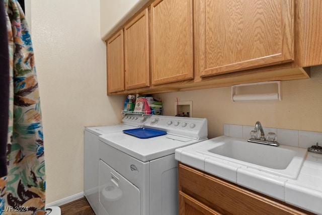 washroom with sink, cabinets, and separate washer and dryer