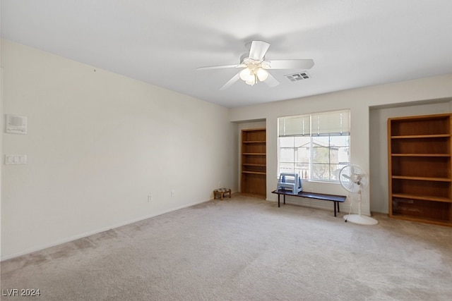 unfurnished living room featuring ceiling fan and carpet