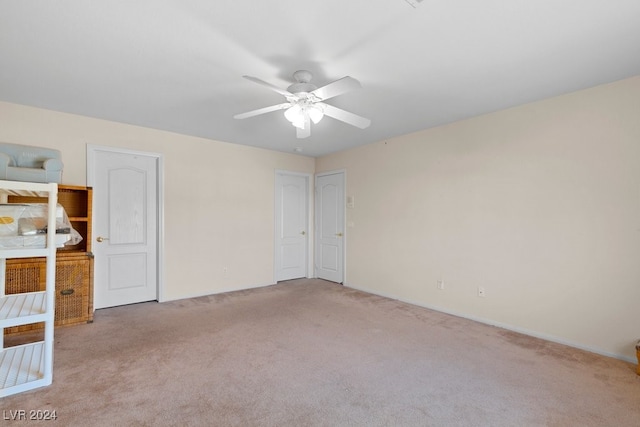 spare room featuring light carpet and ceiling fan