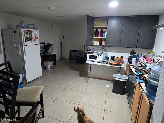 kitchen featuring white appliances and light tile patterned flooring