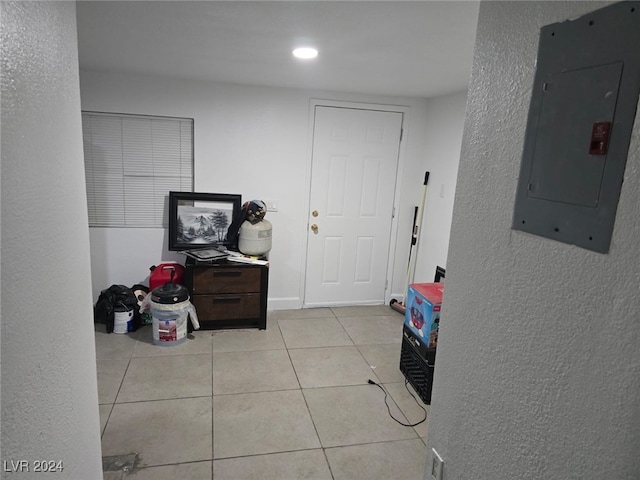 hallway featuring electric panel and light tile patterned flooring