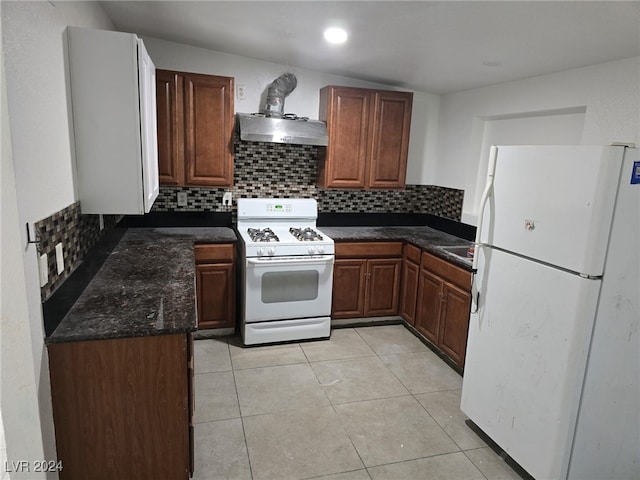 kitchen with white appliances, range hood, light tile patterned floors, and decorative backsplash