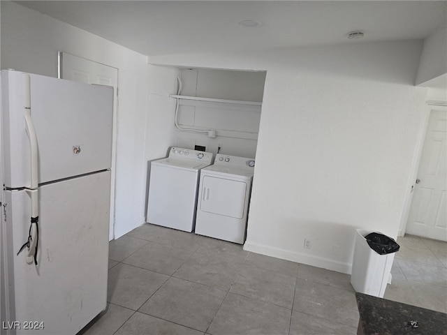 clothes washing area featuring washing machine and dryer and light tile patterned floors