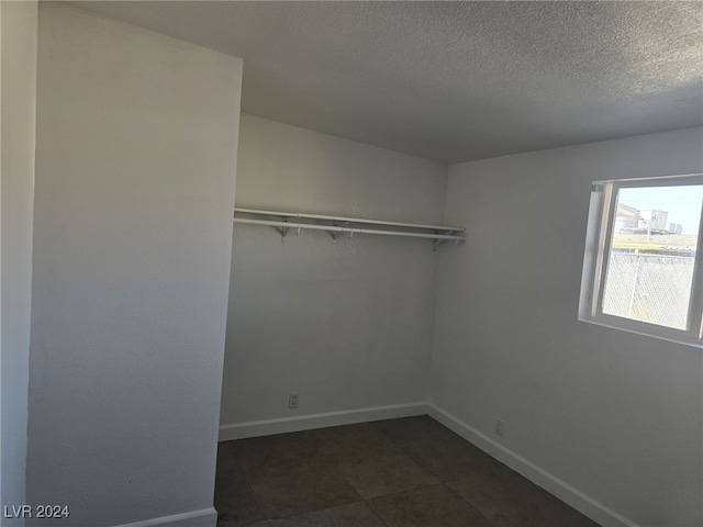 walk in closet featuring dark tile patterned floors