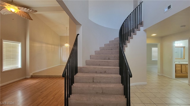 stairway featuring hardwood / wood-style floors, ceiling fan, and sink