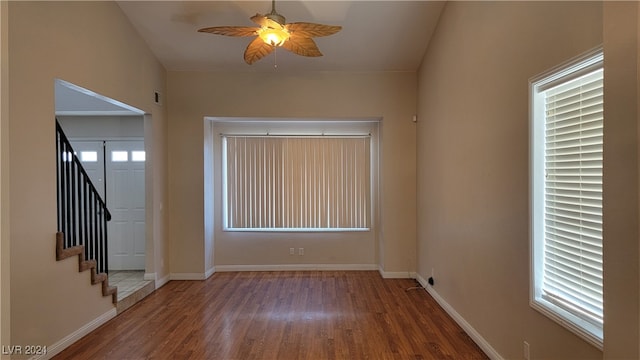 empty room with ceiling fan, dark hardwood / wood-style floors, and a healthy amount of sunlight