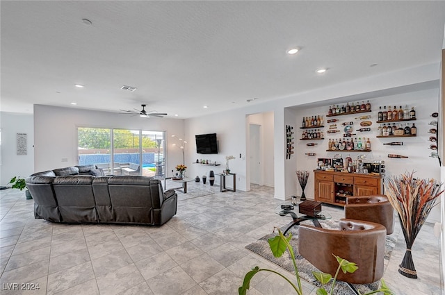 living room with bar area and ceiling fan