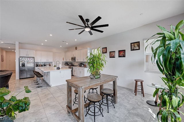 tiled dining area with ceiling fan