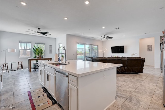 kitchen featuring stainless steel dishwasher, ceiling fan, a center island with sink, and sink