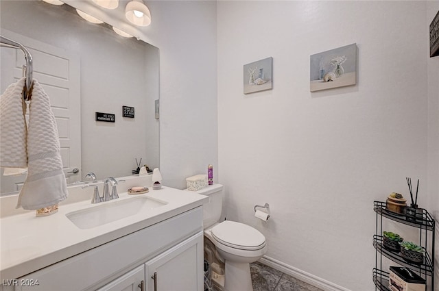 bathroom with tile patterned flooring, vanity, and toilet