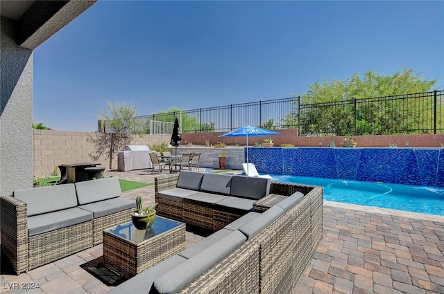 view of patio / terrace with a fenced in pool, an outdoor living space, area for grilling, and pool water feature