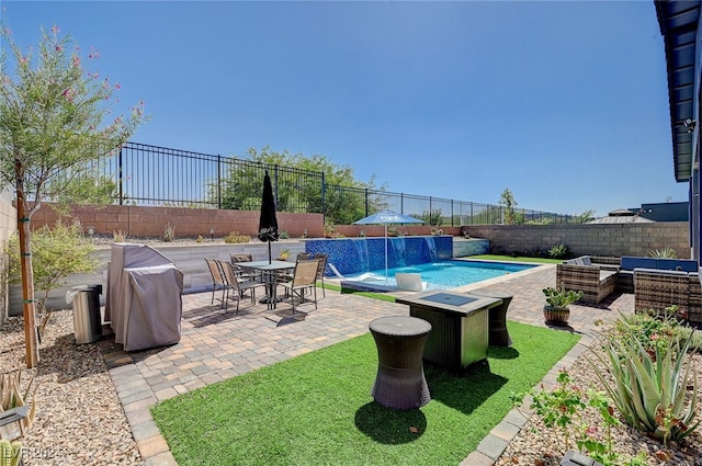 view of swimming pool with pool water feature and a patio area