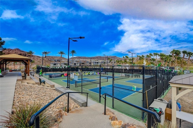 view of tennis court featuring a gazebo and a mountain view