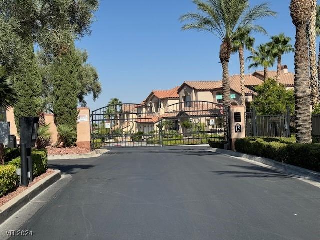 1024 Eaglewood Dr, Las Vegas, NV 89144 - view of asphalt street featuring a gate, curbs, and a gated entry
