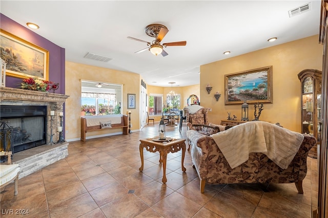 living room featuring ceiling fan, tile patterned floors, and a fireplace