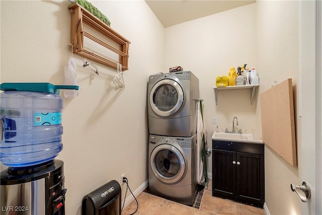 laundry area with stacked washer and dryer, sink, and light tile patterned floors