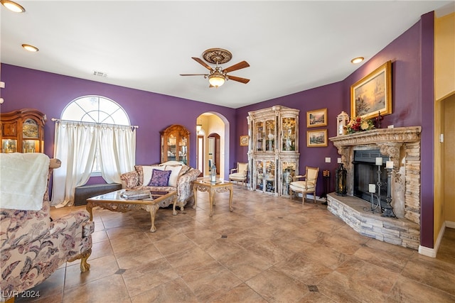 living room featuring ceiling fan and a fireplace