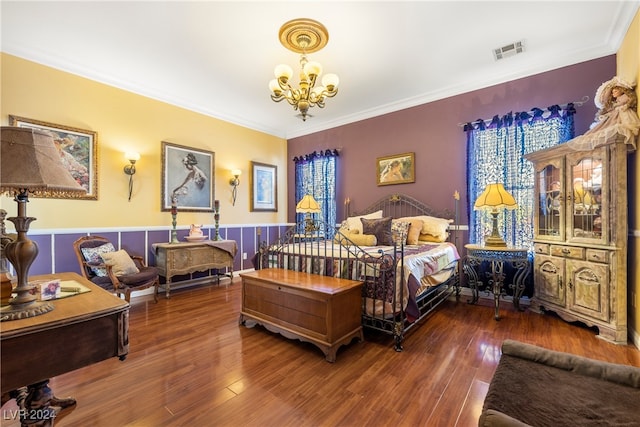 bedroom featuring hardwood / wood-style flooring, ornamental molding, and a chandelier