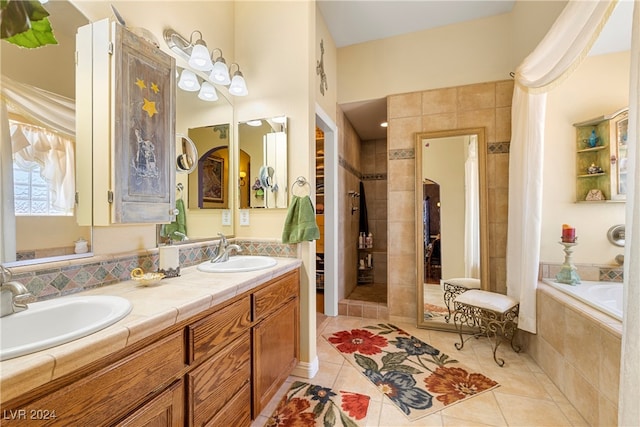 bathroom with tile patterned flooring, vanity, and shower with separate bathtub