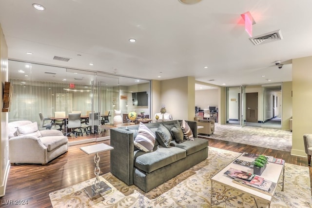 living area featuring recessed lighting, visible vents, and wood finished floors