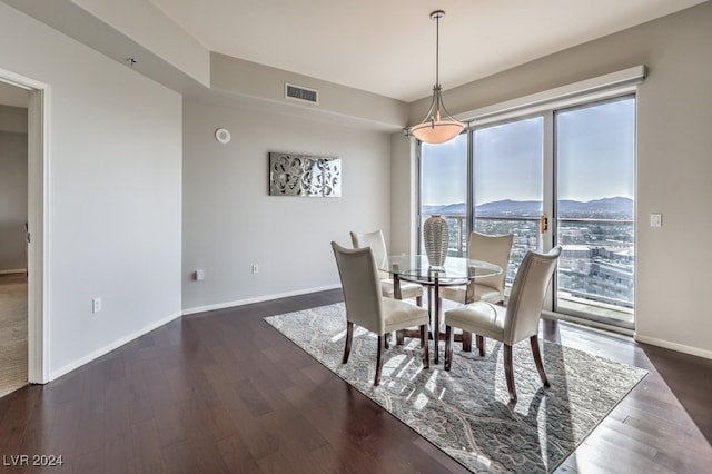 dining area with a mountain view, dark wood-type flooring, visible vents, and baseboards