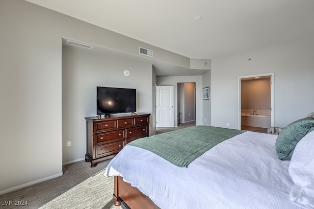 carpeted bedroom featuring baseboards, visible vents, and connected bathroom