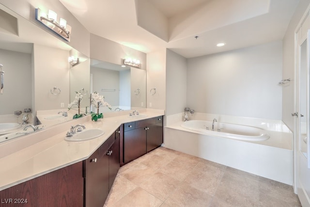 bathroom featuring a bath, double vanity, and a sink