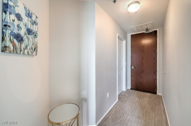 corridor featuring carpet, visible vents, and baseboards